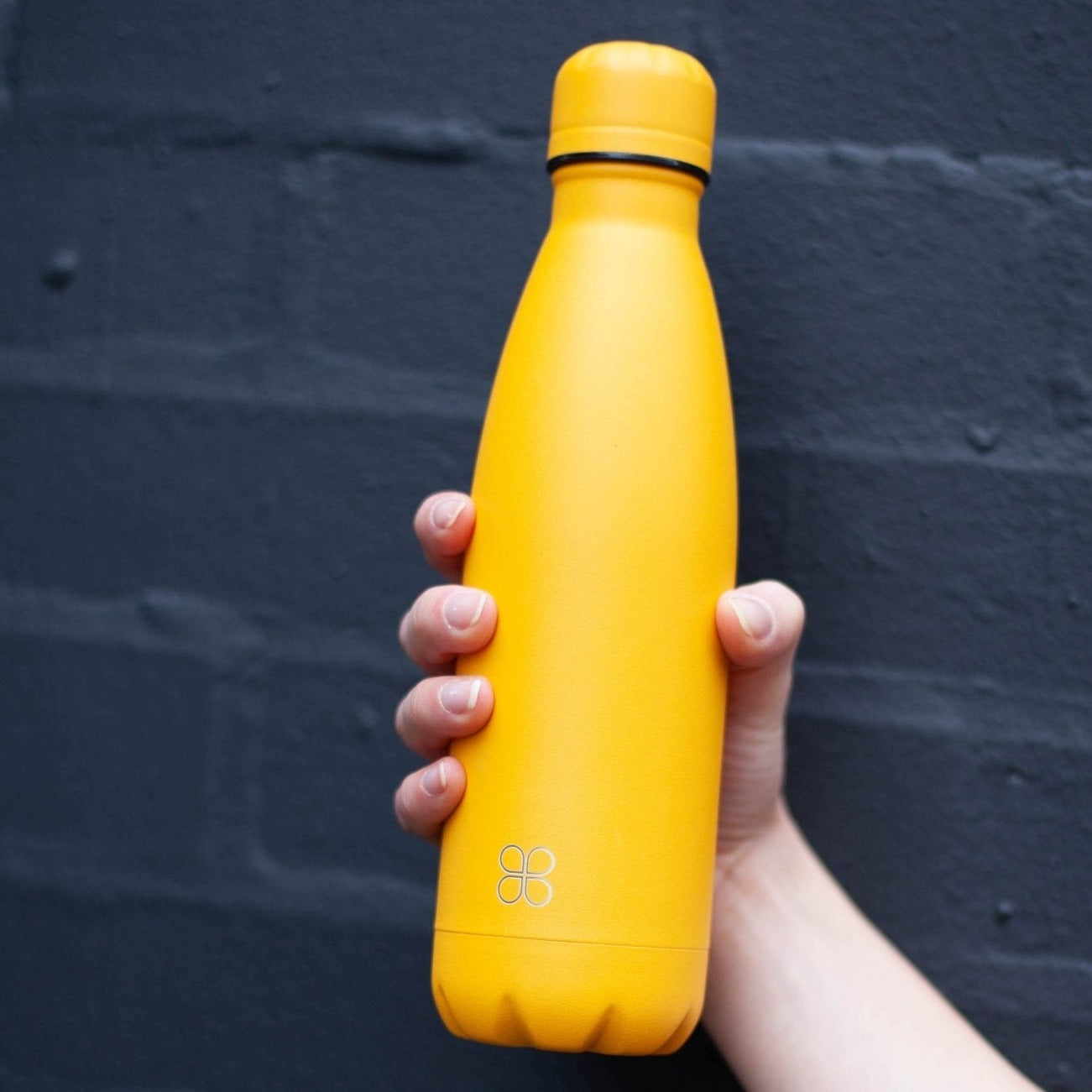 Lady's hand grasping a yellow water bottle